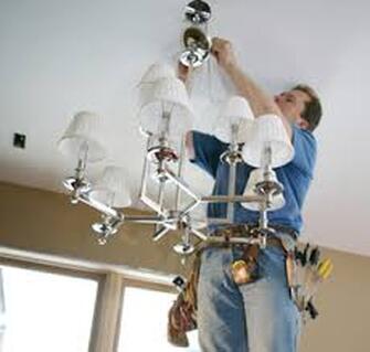Electrician hanging chandelier
